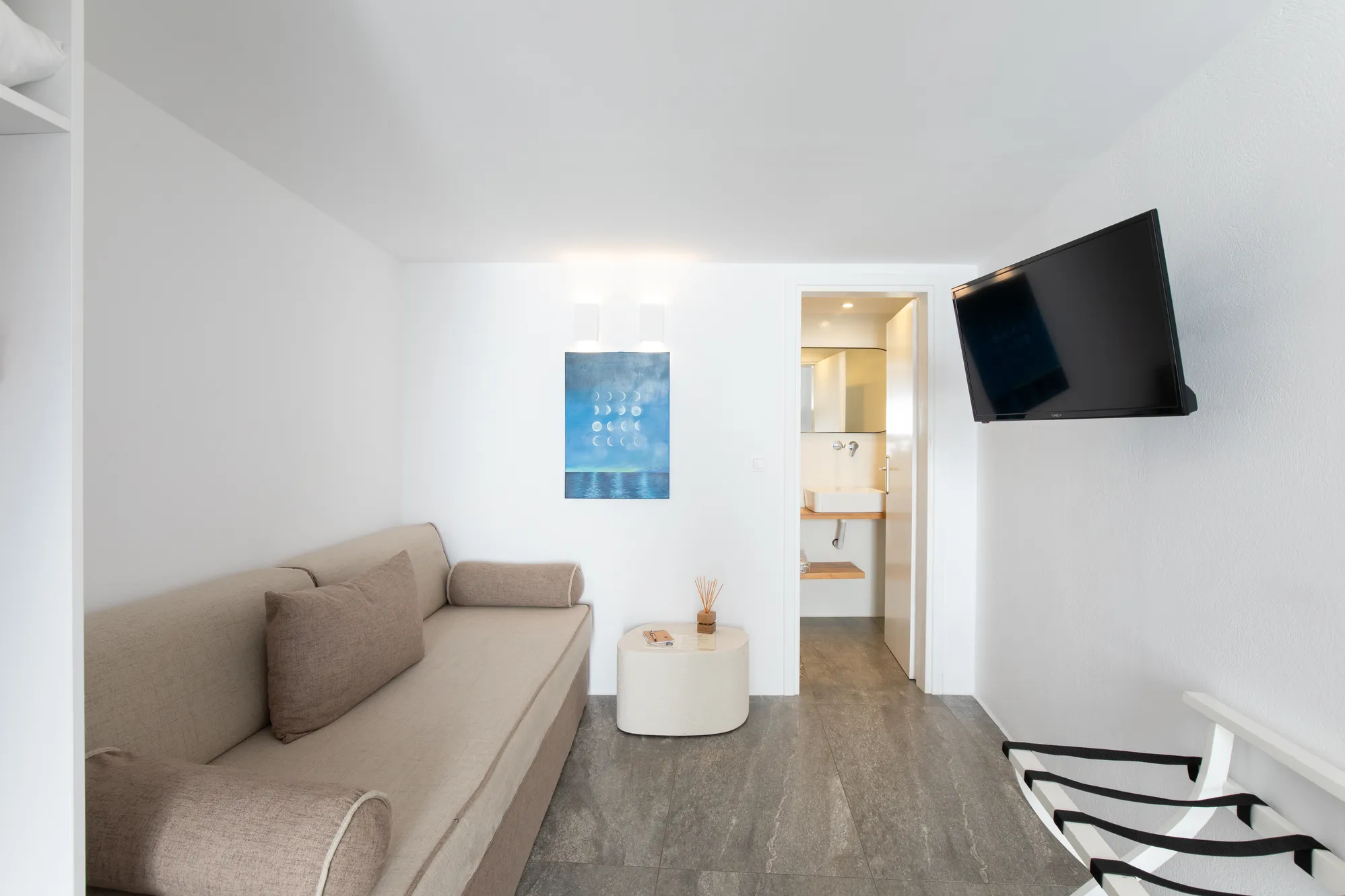 Lounge with sofa, TV and a view to the bathroom
